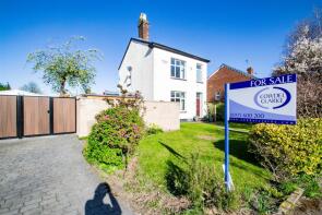 A puréed and simmering carrot soup in a pot with a spoon