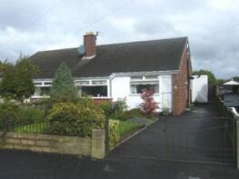 A puréed and simmering carrot soup in a pot with a spoon