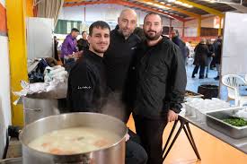 A puréed and simmering carrot soup in a pot with a spoon