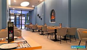 A puréed and simmering carrot soup in a pot with a spoon