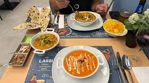 A puréed and simmering carrot soup in a pot with a spoon
