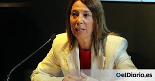 A puréed and simmering carrot soup in a pot with a spoon