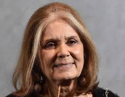 A puréed and simmering carrot soup in a pot with a spoon