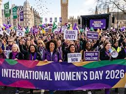 A puréed and simmering carrot soup in a pot with a spoon