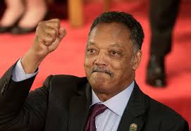 A puréed and simmering carrot soup in a pot with a spoon