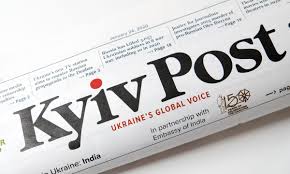 A puréed and simmering carrot soup in a pot with a spoon